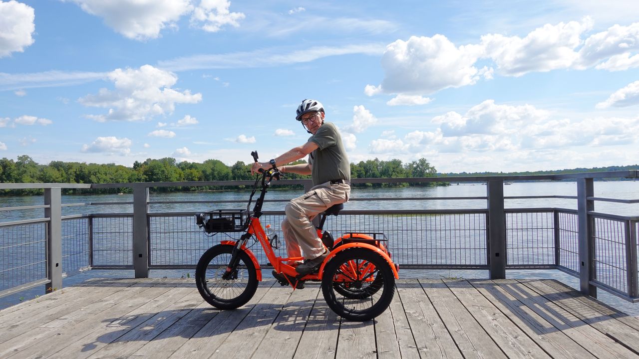 Crafting Captivating Headlines: Your awesome post title goes here Elderly man enjoying a ride on an electric tricycle by the waterfront on a sunny day.